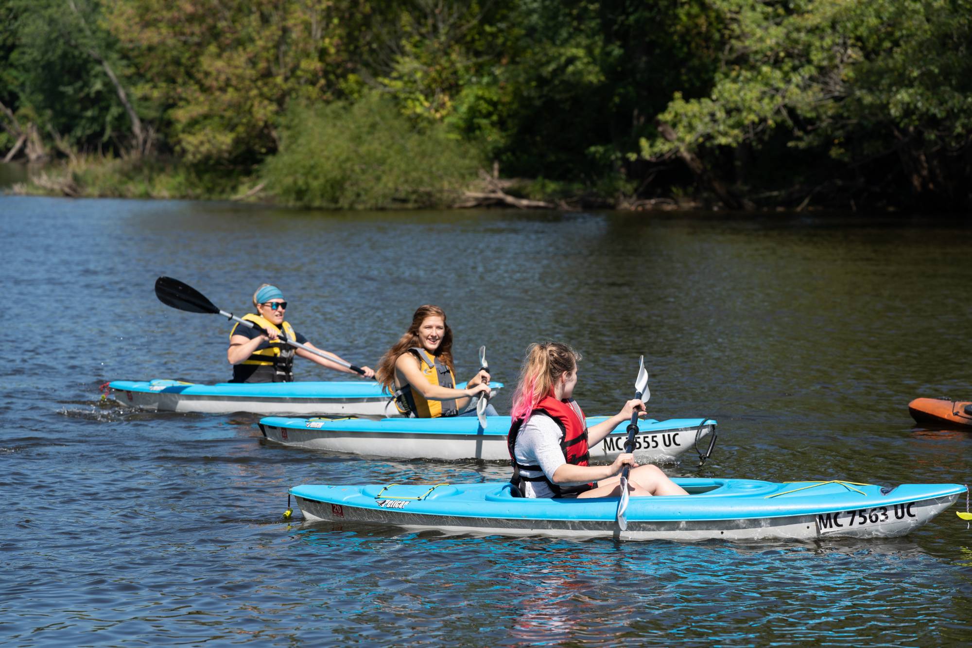 three people in kayaks